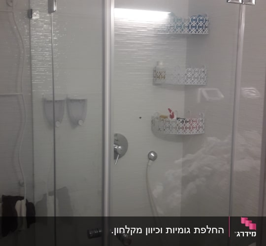 מקלחון פינתי מזכוכית שקופה עם דלתות פתיחה בחדר רחצה